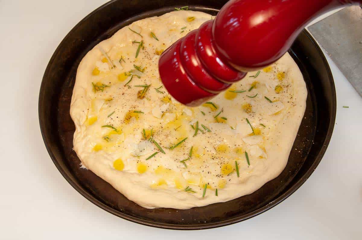 Putting the toppings on the dough before baking.