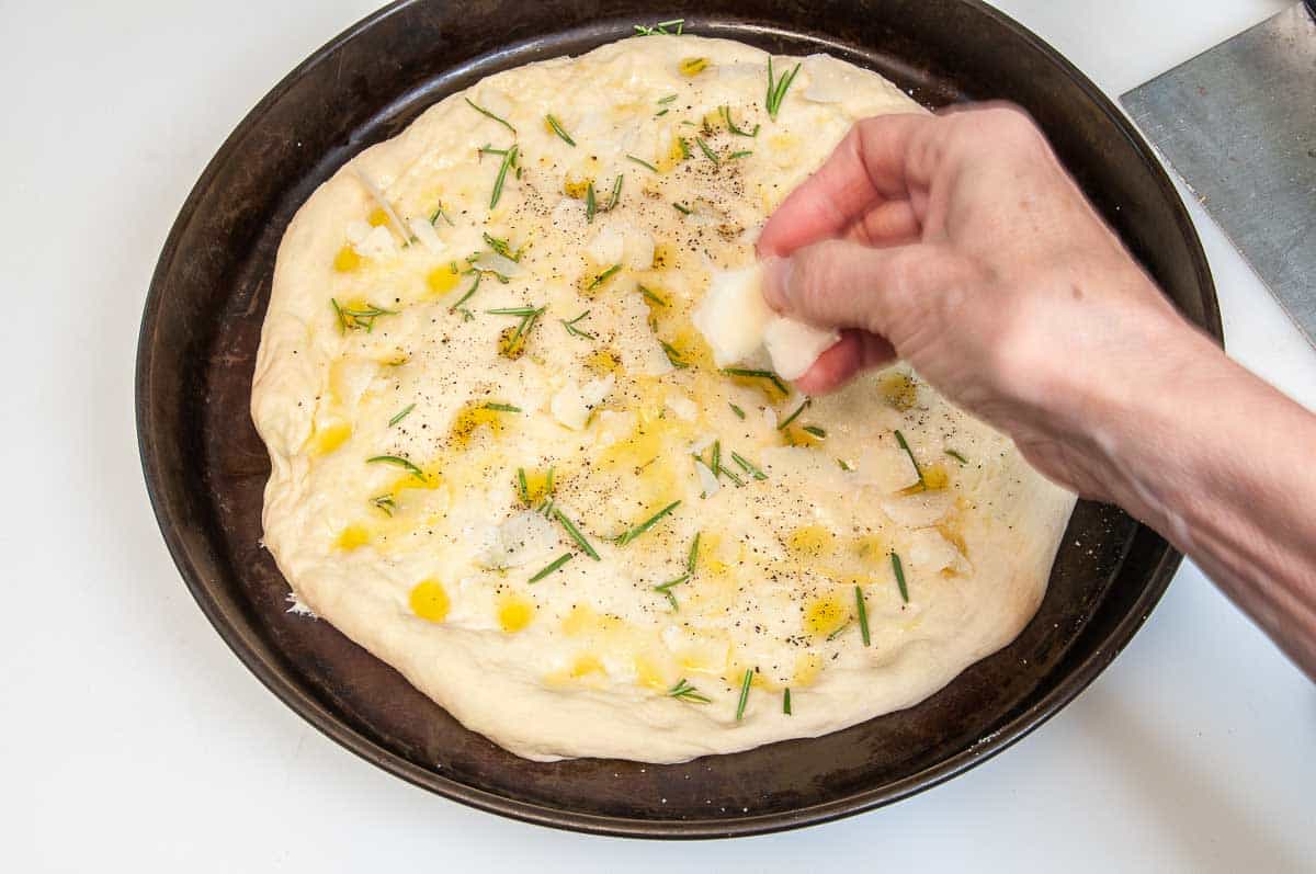 Adding rosemary, seasonings and cheese to the top.
