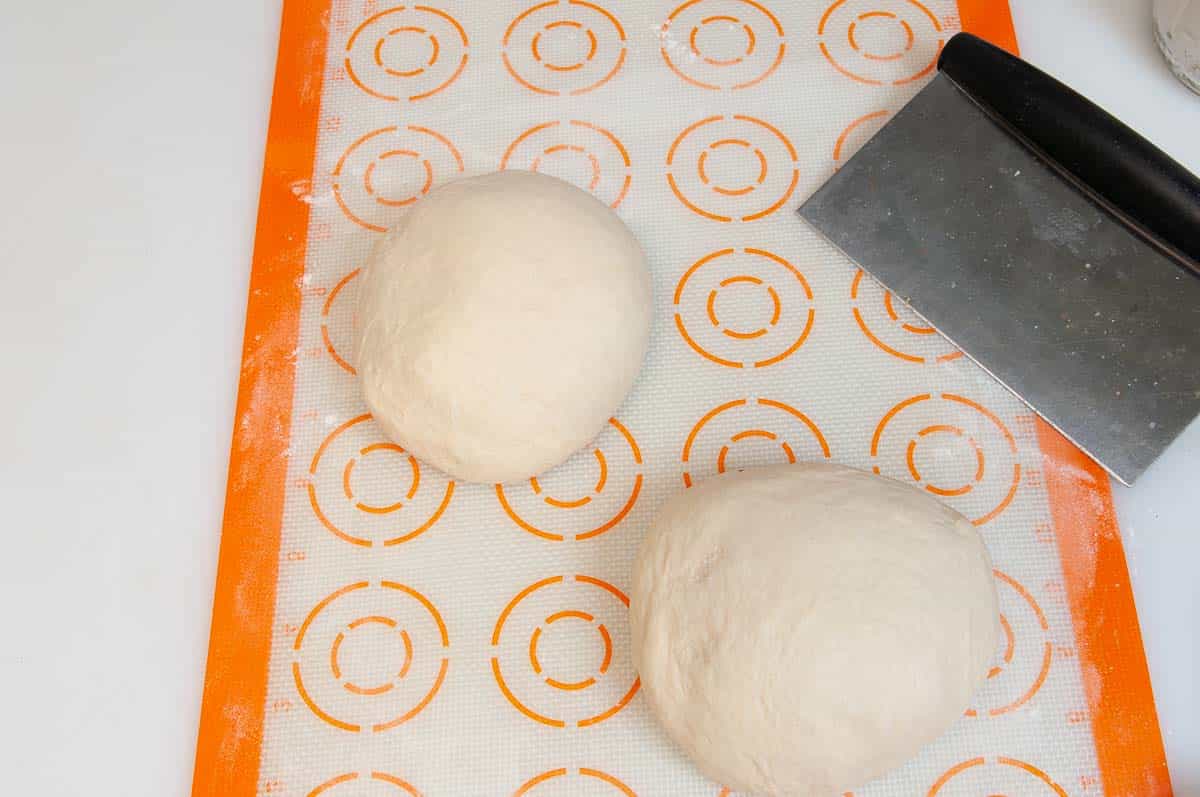 Dividing dough into two balls or portions.