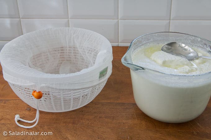 transferring yogurt to pouch stretched over a colander