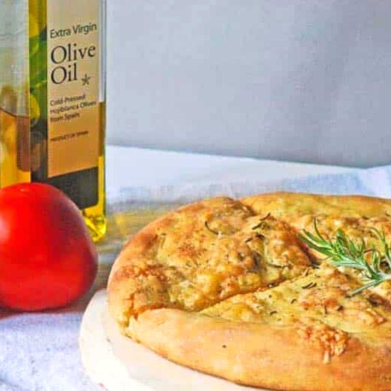 quartered baked focaccia next to a tomato and olive oil