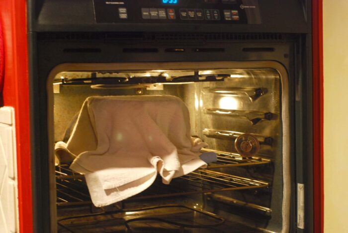 Incubating the yogurt (covered with a towelin a warm oven