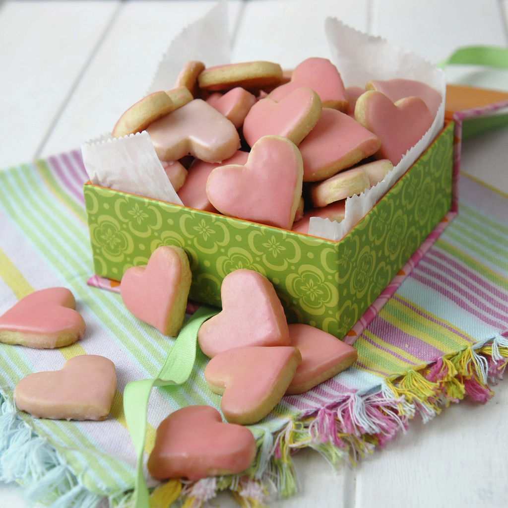 simple iced shortbread cookies shaped like hearts and decorated with pink icing.