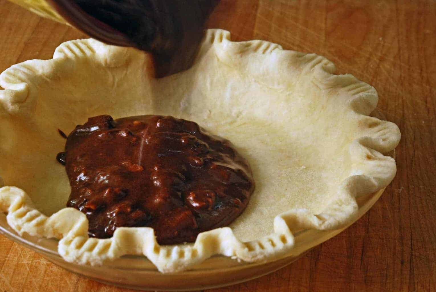 showing raw flaky pie crust with shortening with some filling