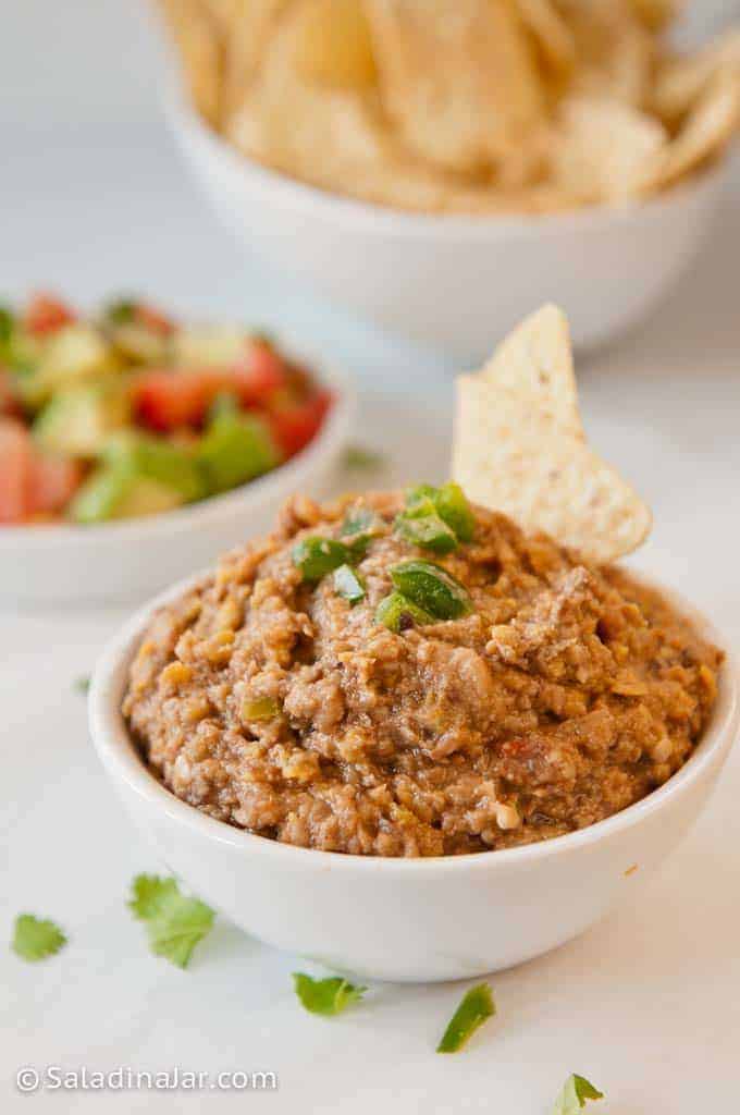Refried Black-Eyed Peas Dip in a bowl with jalapeno garnish and chips