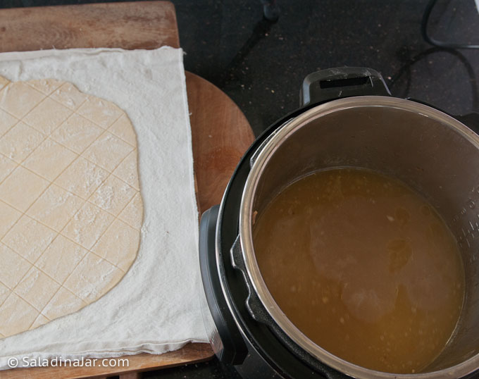 dumping dough--rolled, cut and ready to drop into the broth
