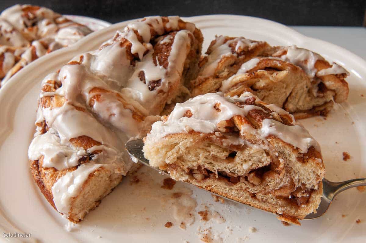 prominent slice of braided cinnamon bread in front of uncut bread