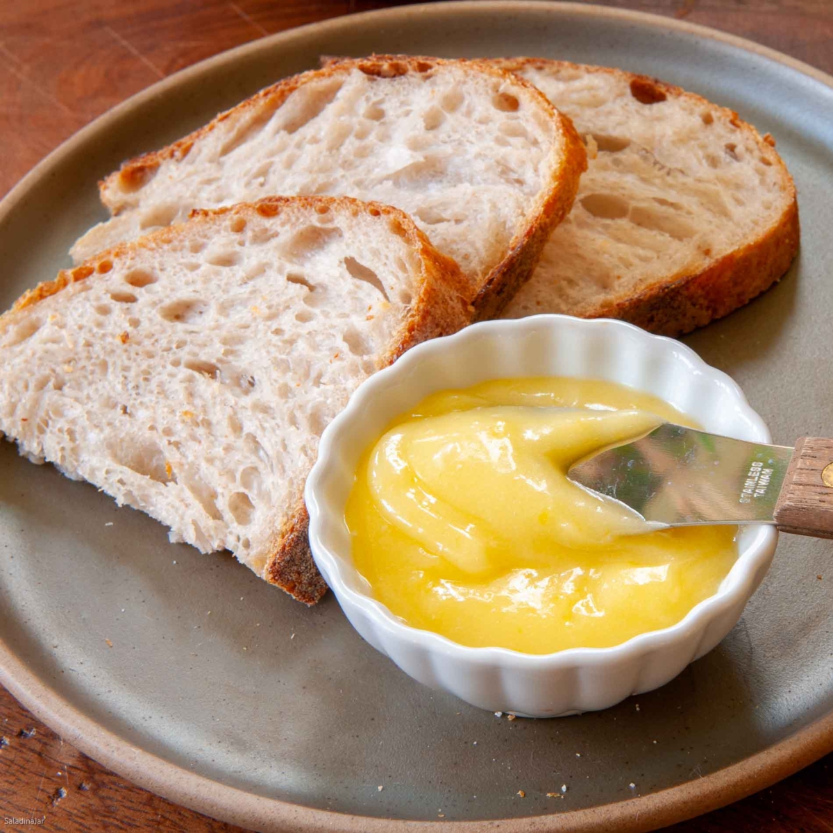 lemon curd in a dish with slices of sourdough bread