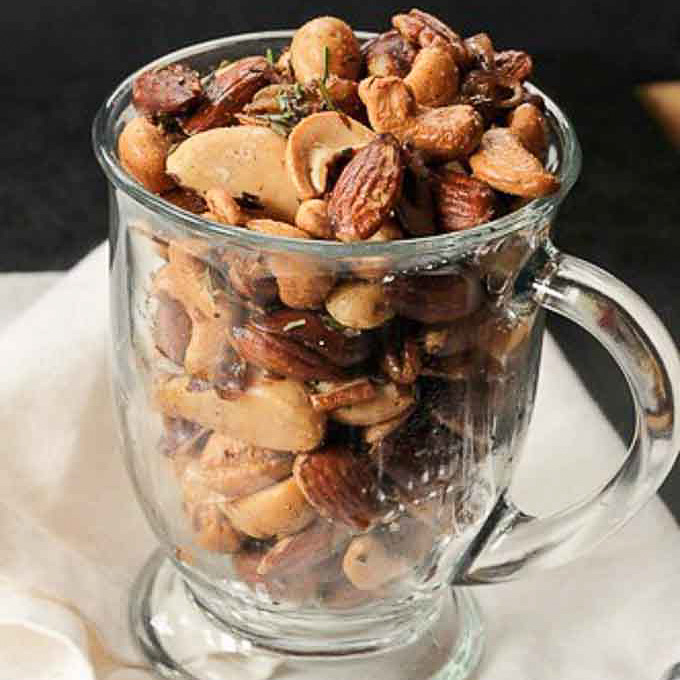 warm nuts with rosemary in a mug