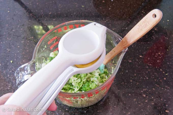 squeezing lemon over cooked broccoli