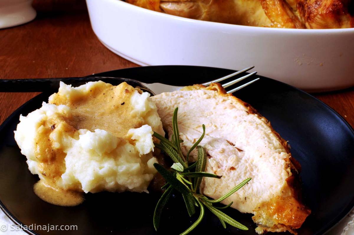 rosemary chicken alongside mashed potatoes and instant gravy.