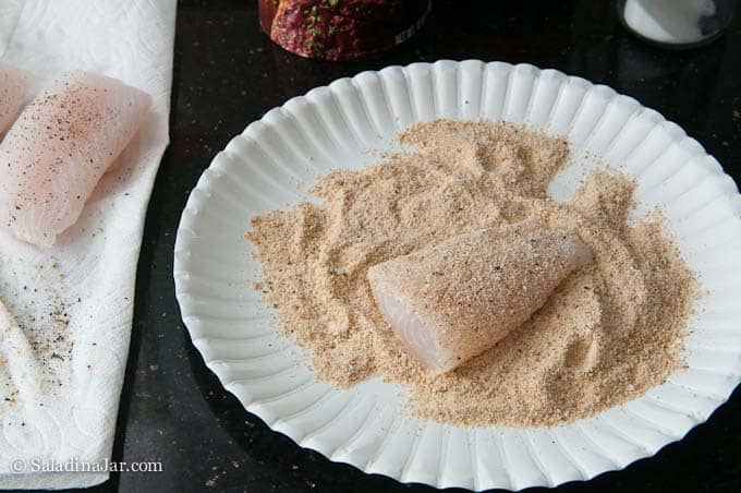 Rolling fish fillets in bread crumbs