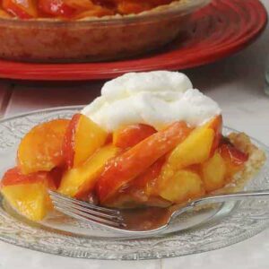 slice of fresh nectarine pie with a fork on the plate.