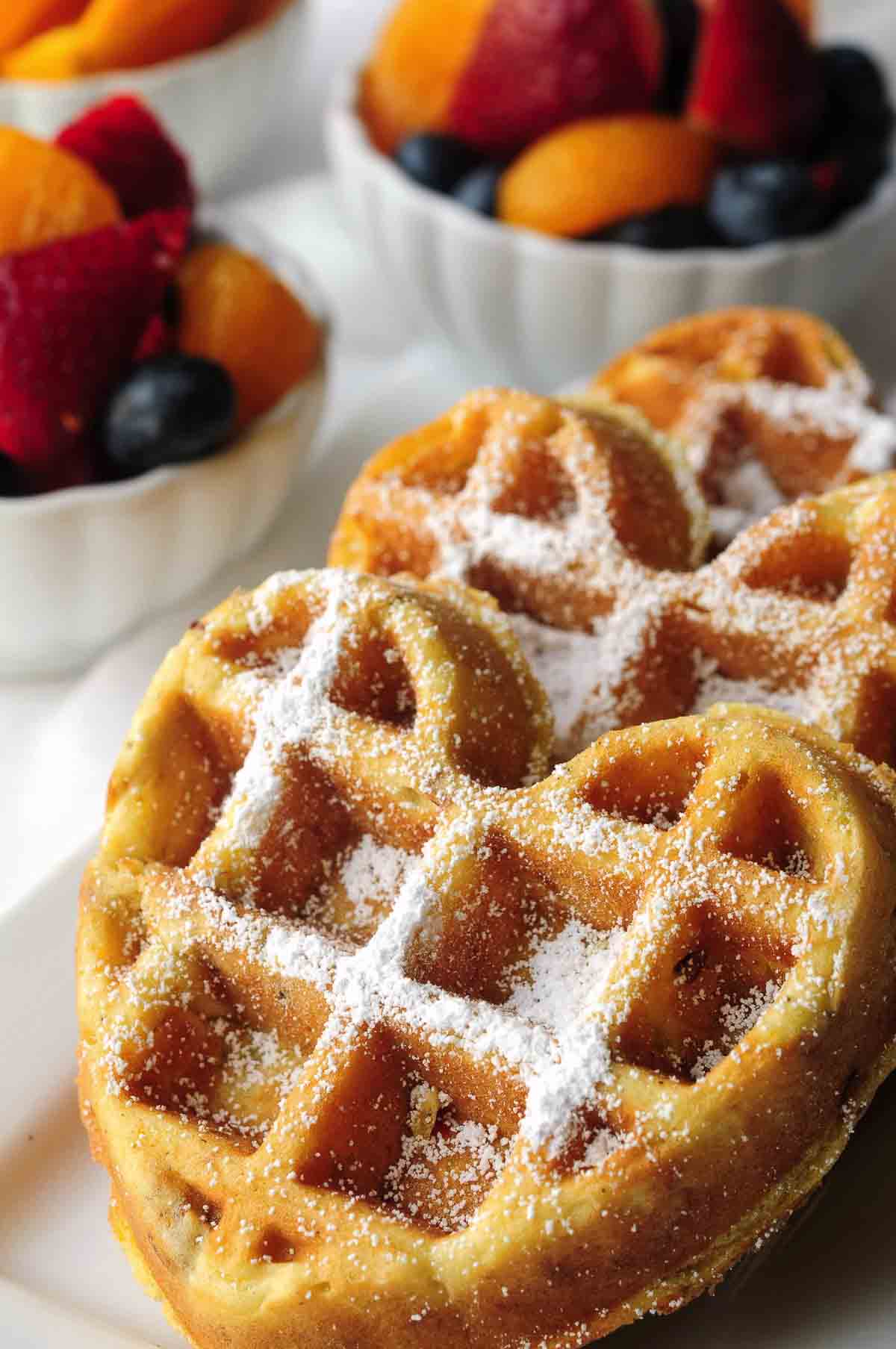 orange waffles with fruit in the background