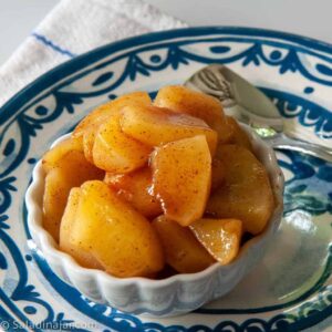 microwave cinnamon apples in a bowl with a spoon on the side