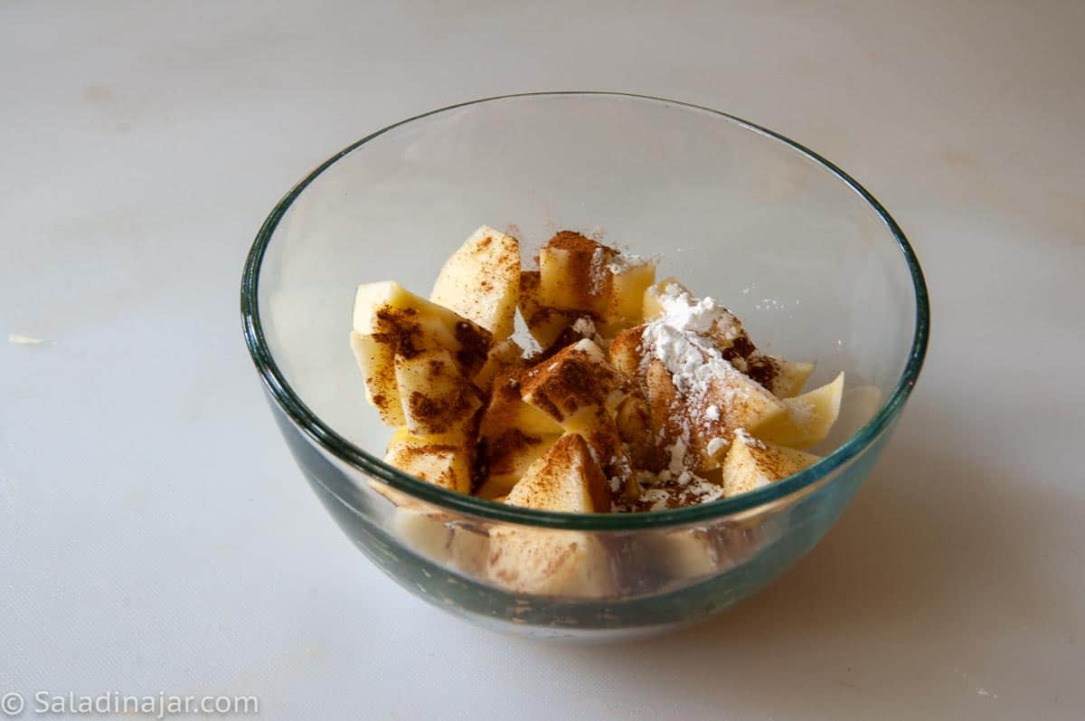 raw apples with sugar and cinnamon in a bowl