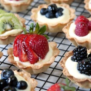 mini fresh fruit tarts on a cooling rack.