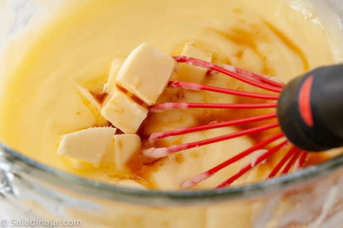 Whisking butter and vanilla into pastry cream after cookiung.