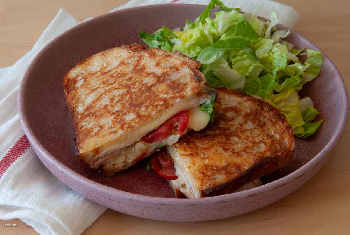 Smoked turkey melt sandwich on a plate with lettuce