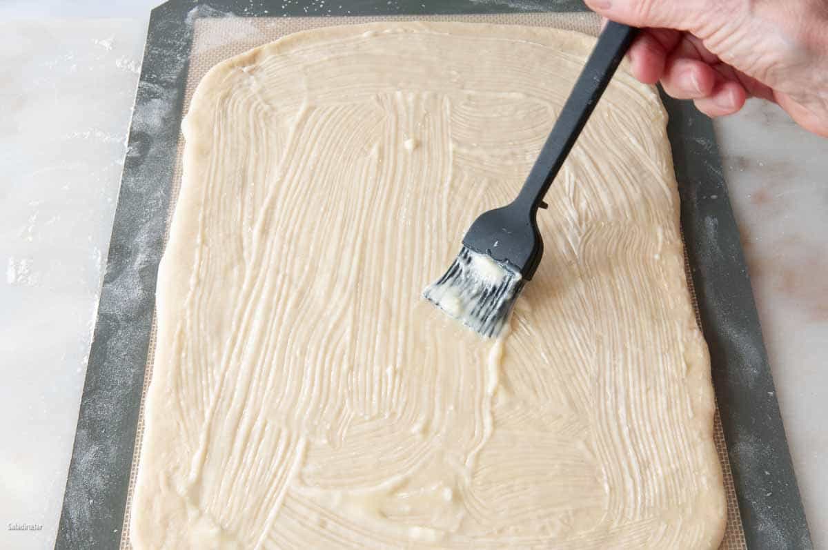 Brusing butter on the rectangle.