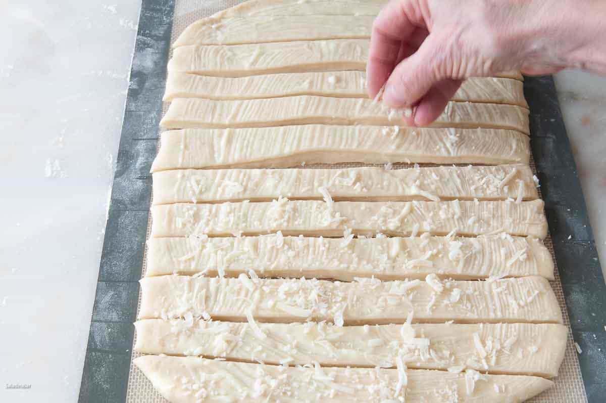 sprinkling strips with Parmesan cheese.