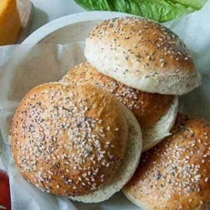 multi-grain hamburger buns in a wooden bowl