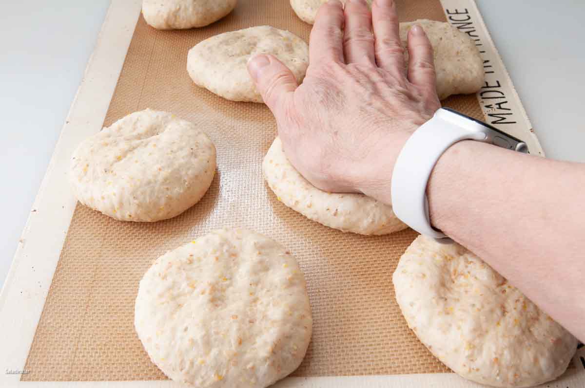 flattening the buns one more time with the palms of hand.