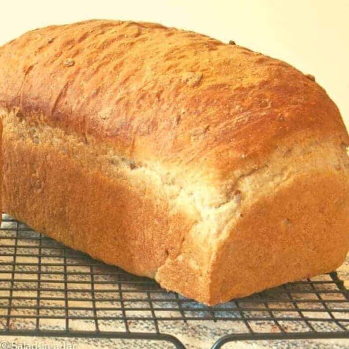 Unsliced loaf of Oatmeal-Sunflower Bread on cooling rack