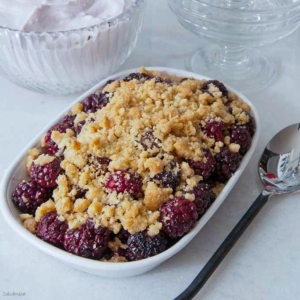 blackberry cobbler for 2 in a dish with a serving spoon