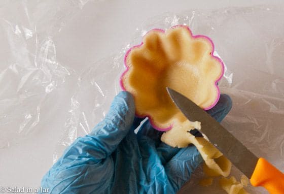 trimming the crust of a tart shell with a knife