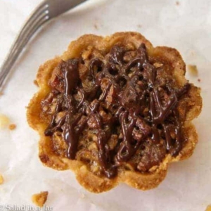 pecan pie tartlet with chocolate drizzle and homemade crust