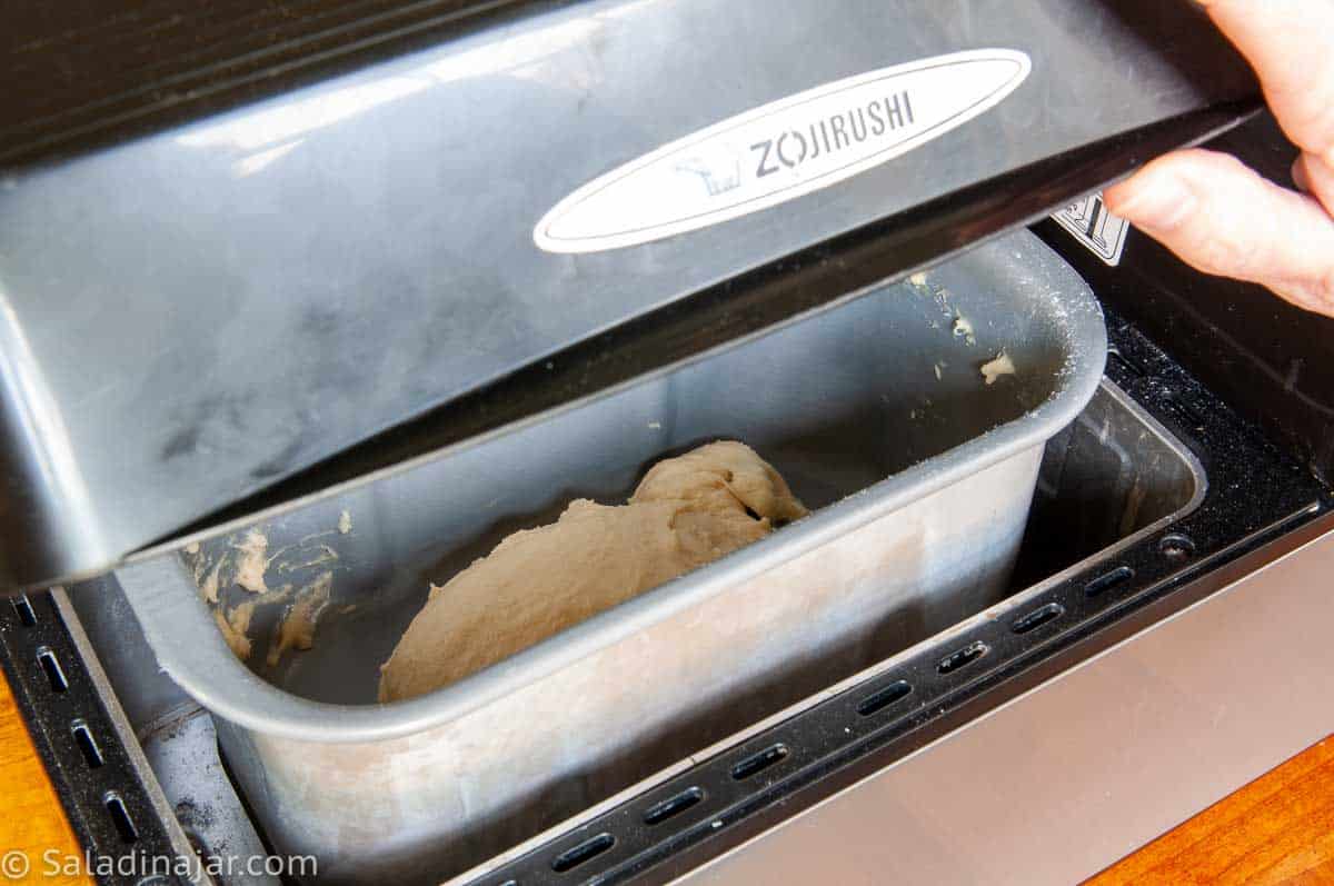 opening the lid to look inside the bread machine