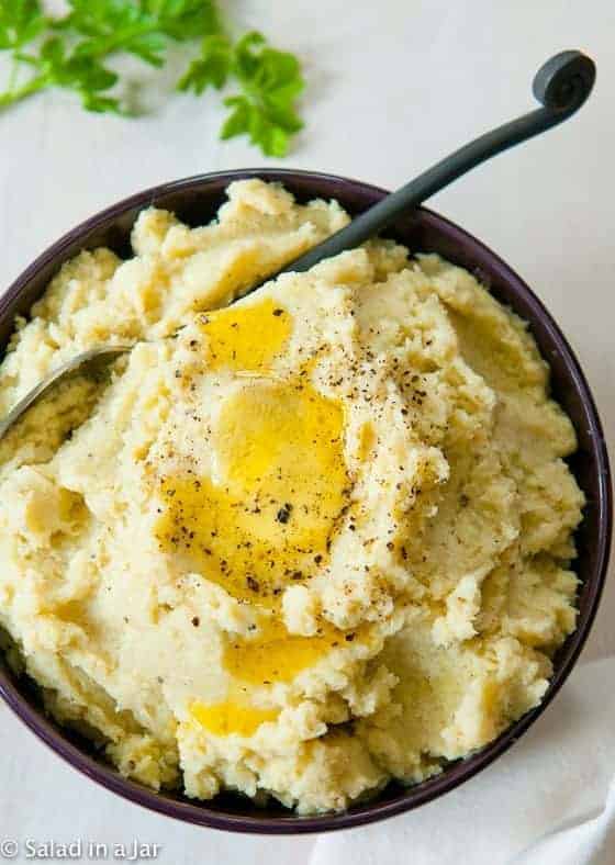 Non-Soggy Mashed Cauliflower in a serving dish with lots of butter and pepper