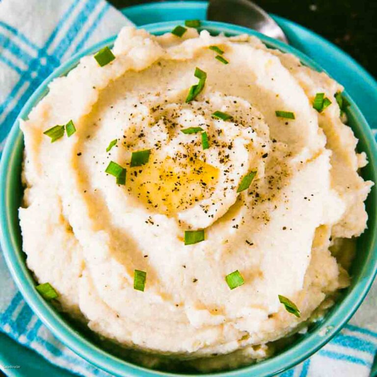mashed cauliflower in a bowl garnished with butter and parsley
