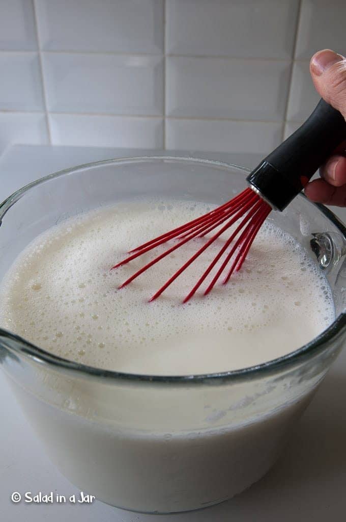 Whisking starter into milk.