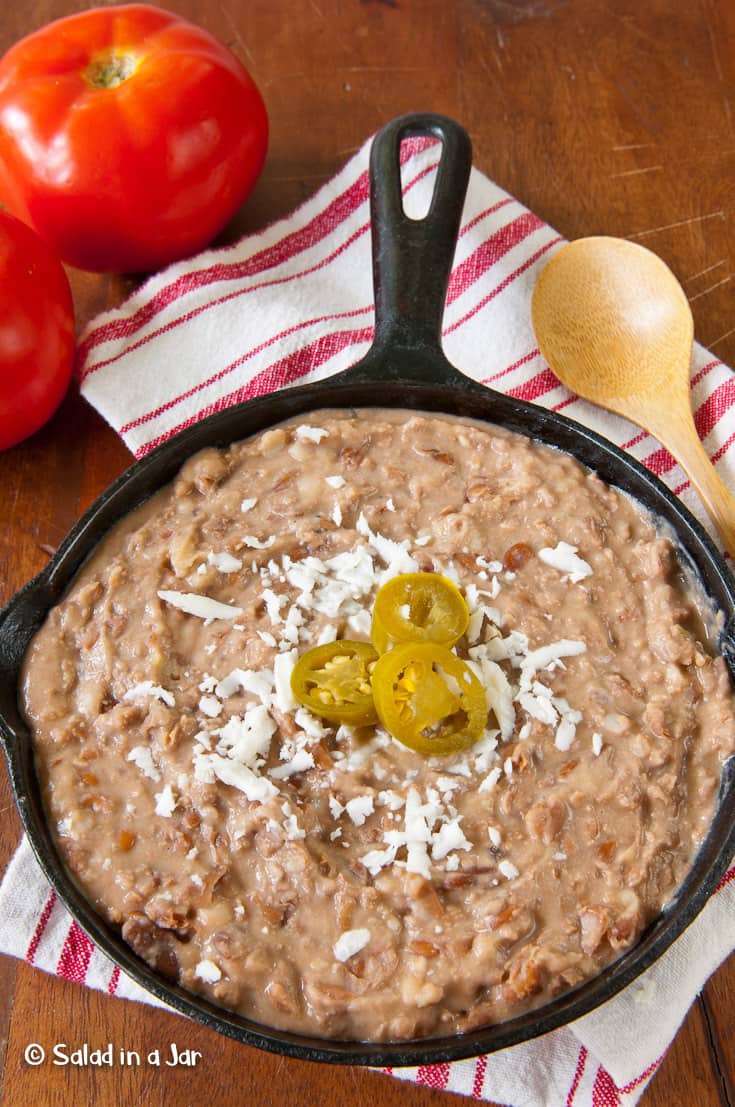 Refried Beans garnished with cheese and jalapeño peppers