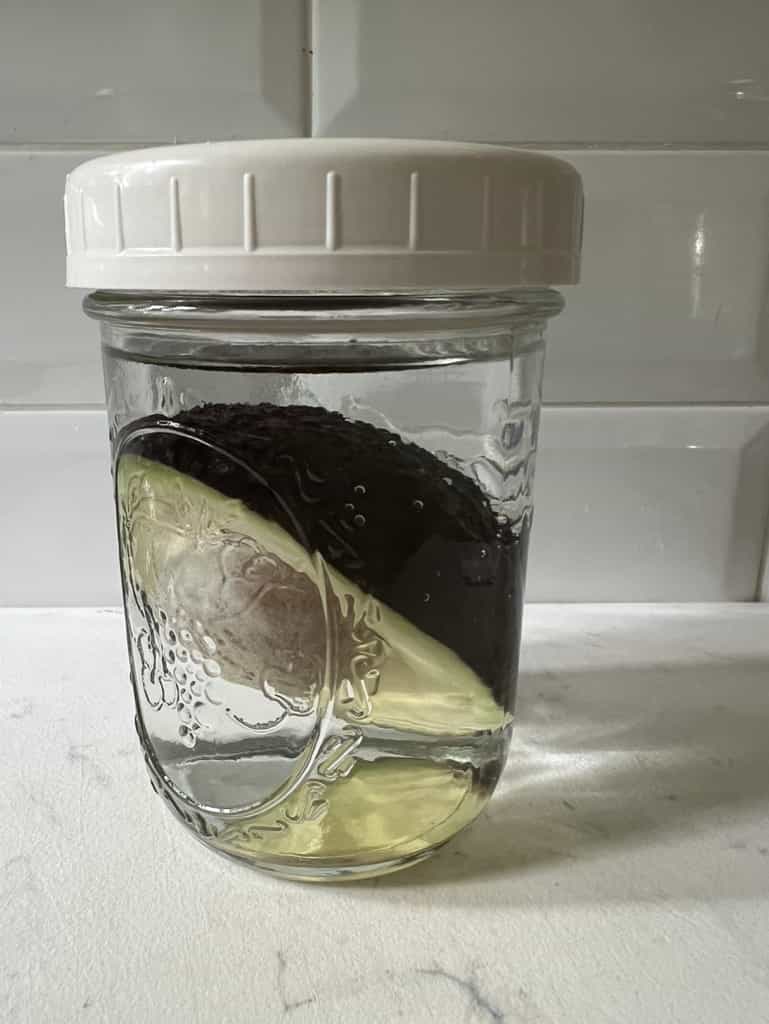 storing unused avocado in a jar of water