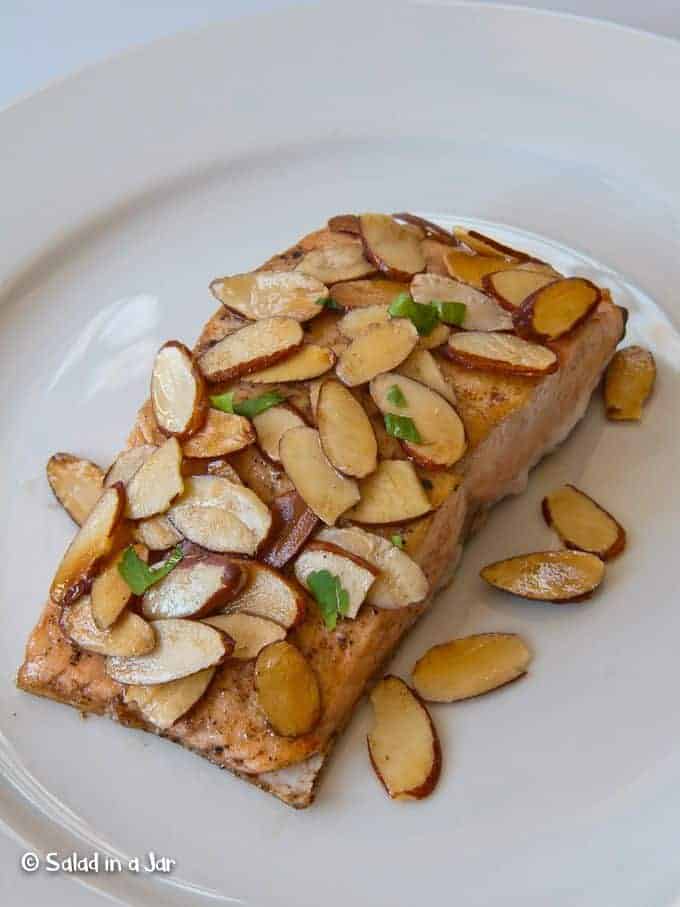 Almond Salmon on a plate covered with toasted almonds