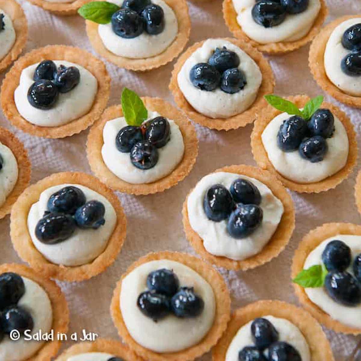Mascarpone Cheese cake mini tarts with blueberries on a serving tray.