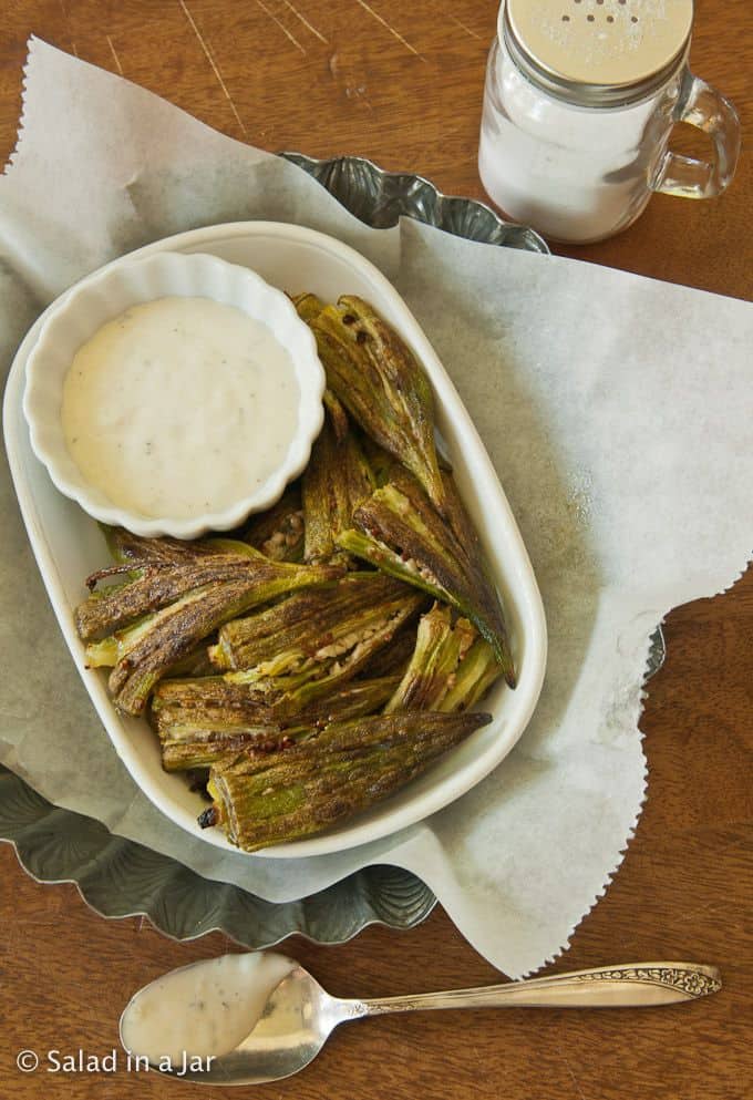 Simple Baked Okra served with ranch dressing and salt on the side.