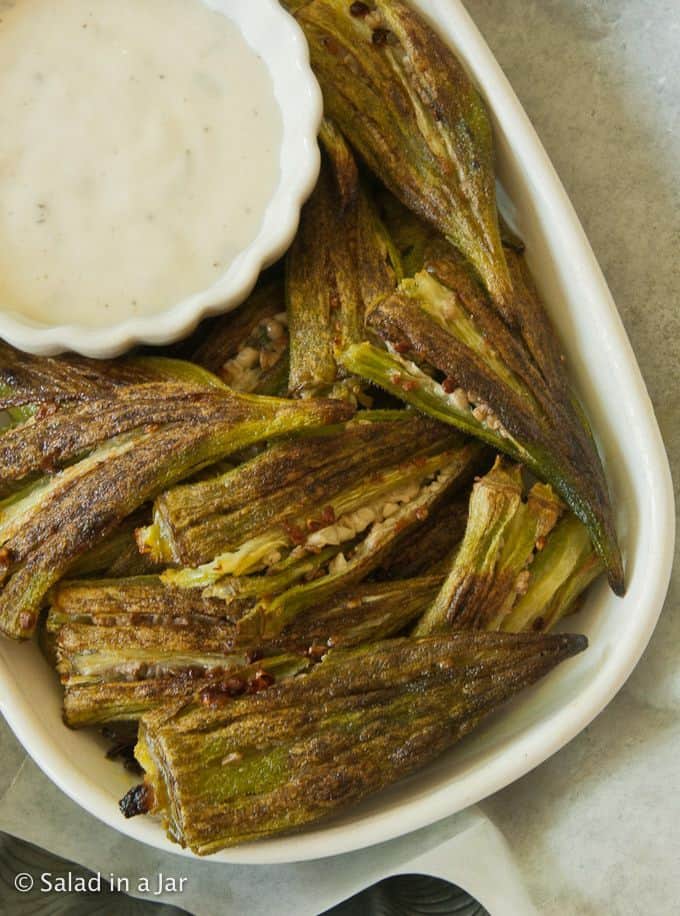 Close-up of roasted okra with a dish of Ranch dressing for dipping.