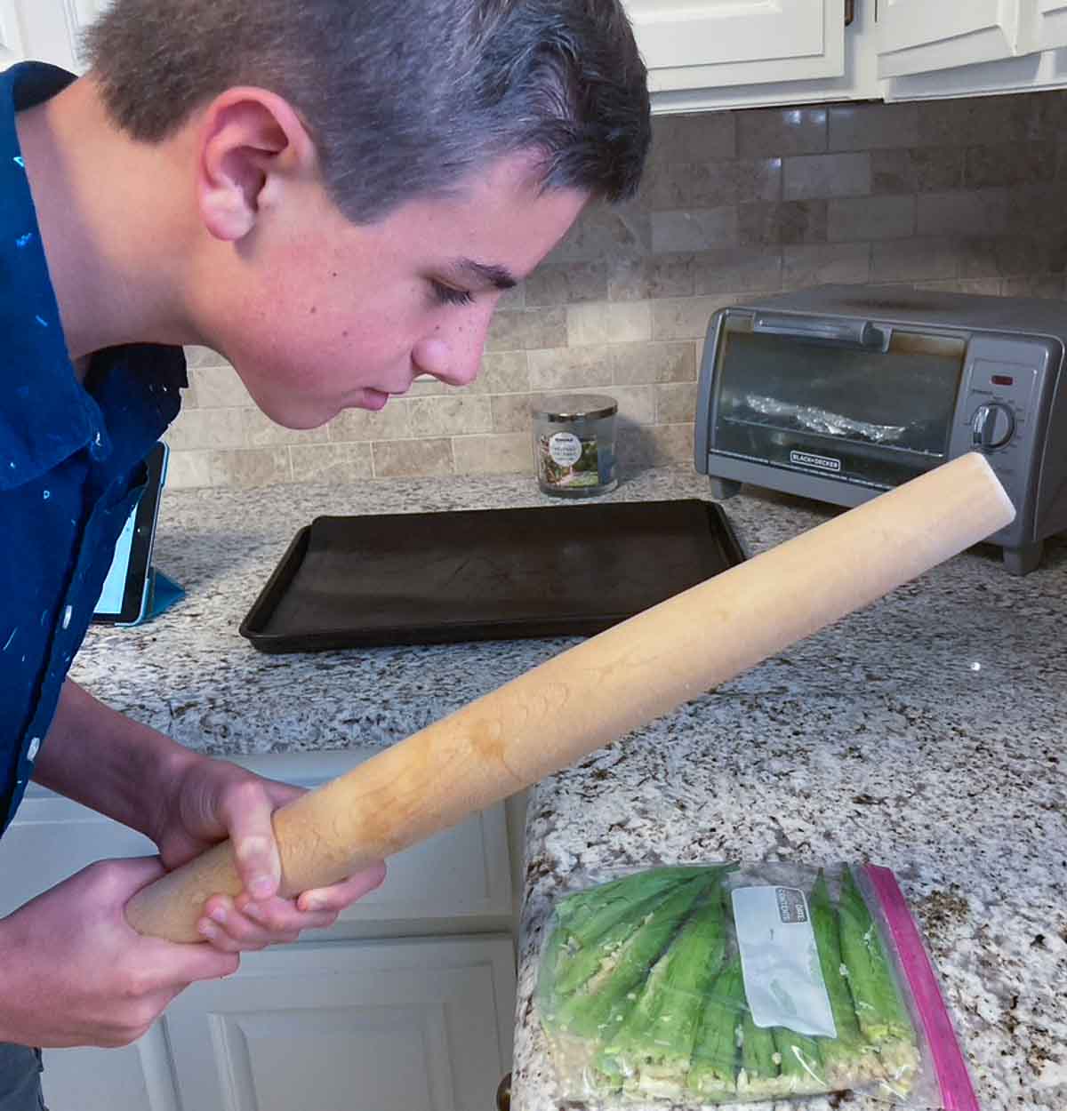 smashing okra  inside a ziplock bag with a rolling pin