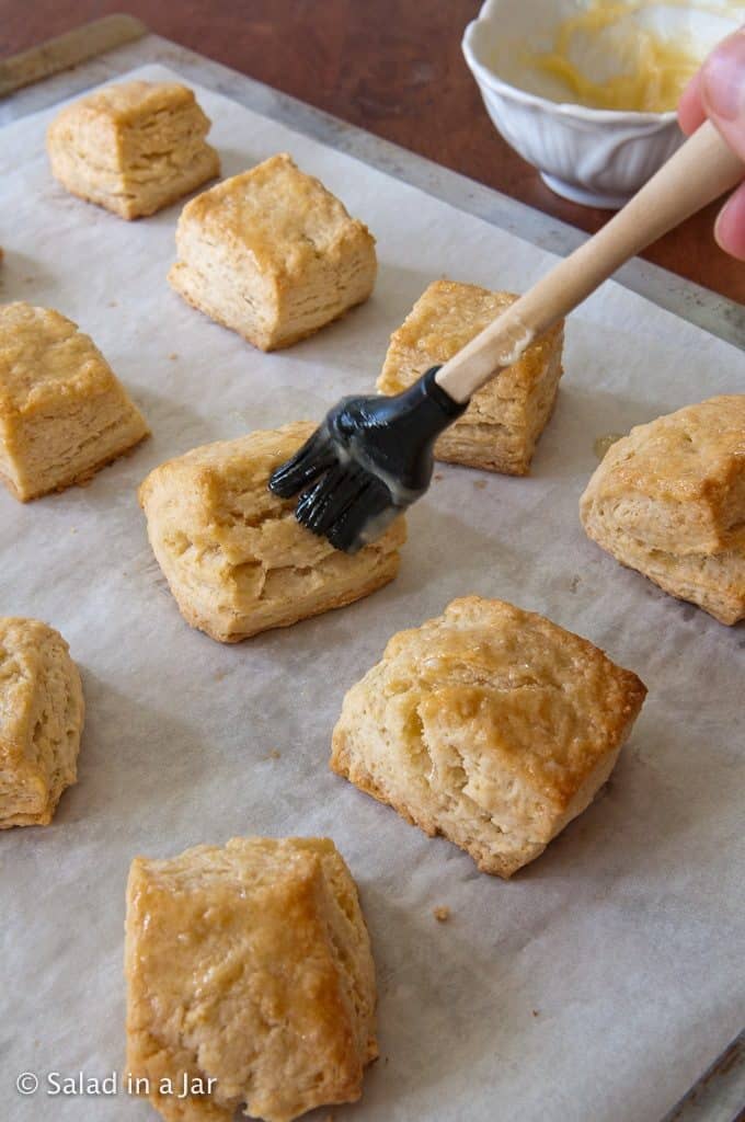 Brushing baked whey biscuits with honey butter