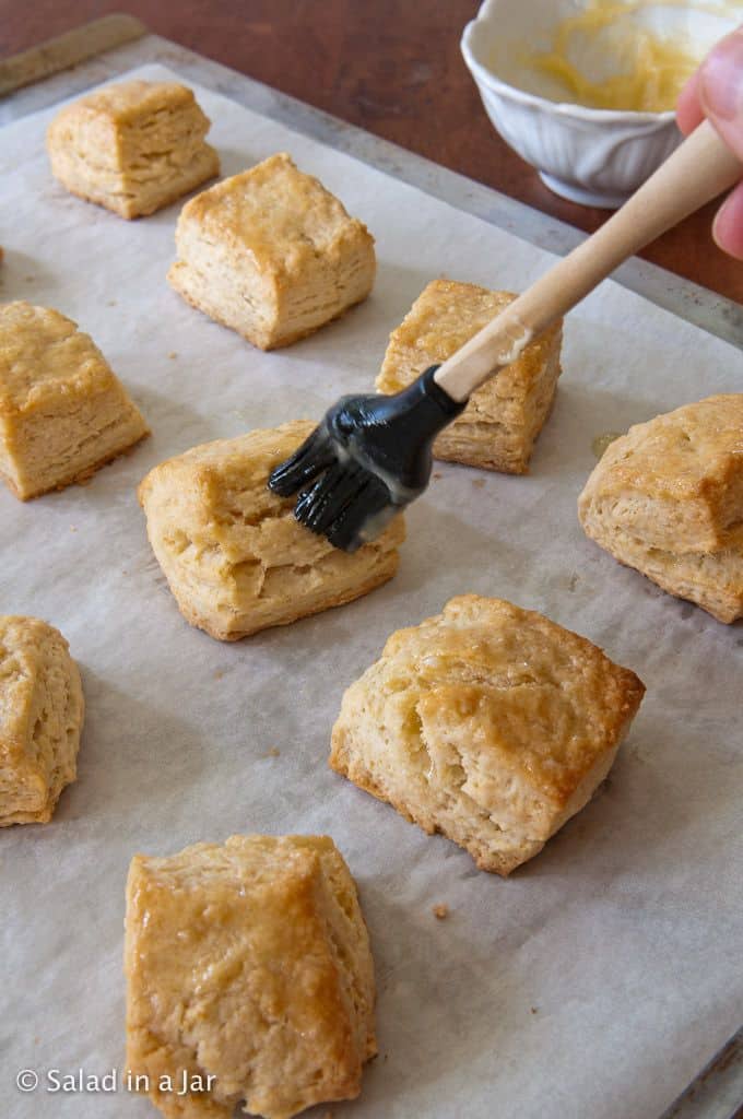 Brushing flaky whey biscuits with honey butter