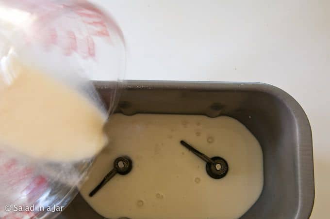 pouring the Tangzhong mixture into a bread machine.