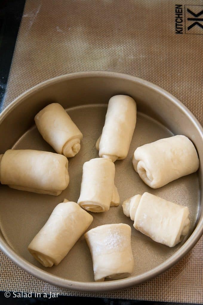 arranging each roll in the pan.
