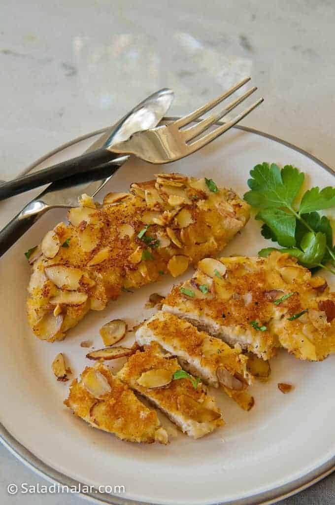 Sliced Easy Breaded Almond Chicken tenders on a plate with silverware