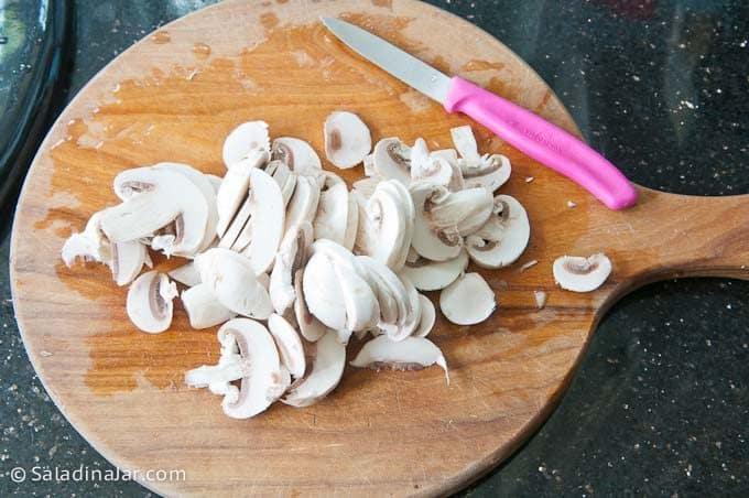 slice mushrooms on cutting board.