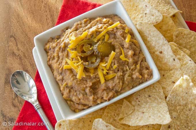 bean dip with sliced jalapenos on top and shredded cheese