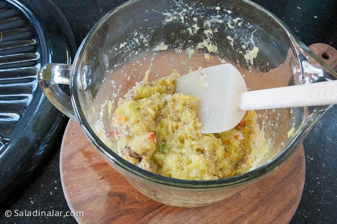 Combining bread crumbs into cooked veggies.